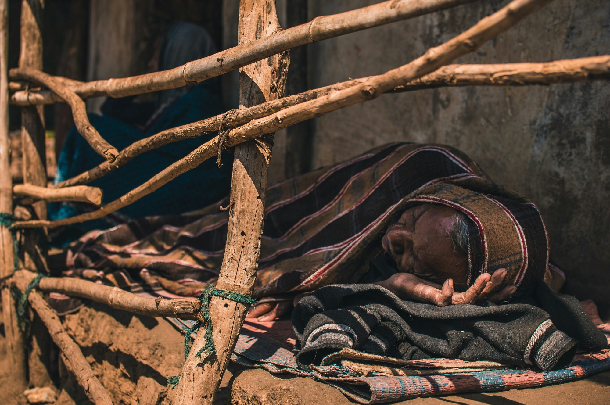 Person sleeping on the floor under a blanket
